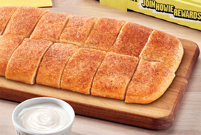 Howie Bread sprinkled with pumpkin spice and a side of white icing.