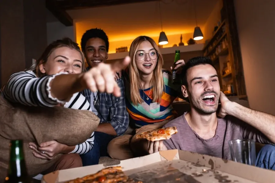 Four friends joined together to watch the game while eating a Hungry Howie's pizza."